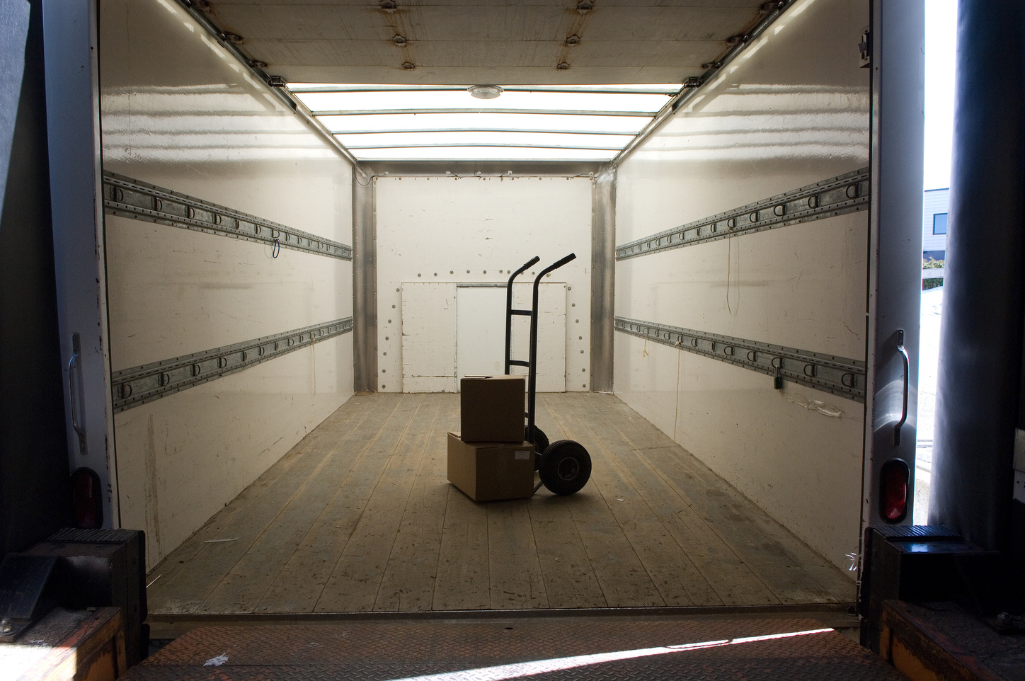 Hand truck and boxes inside truck at loading dock